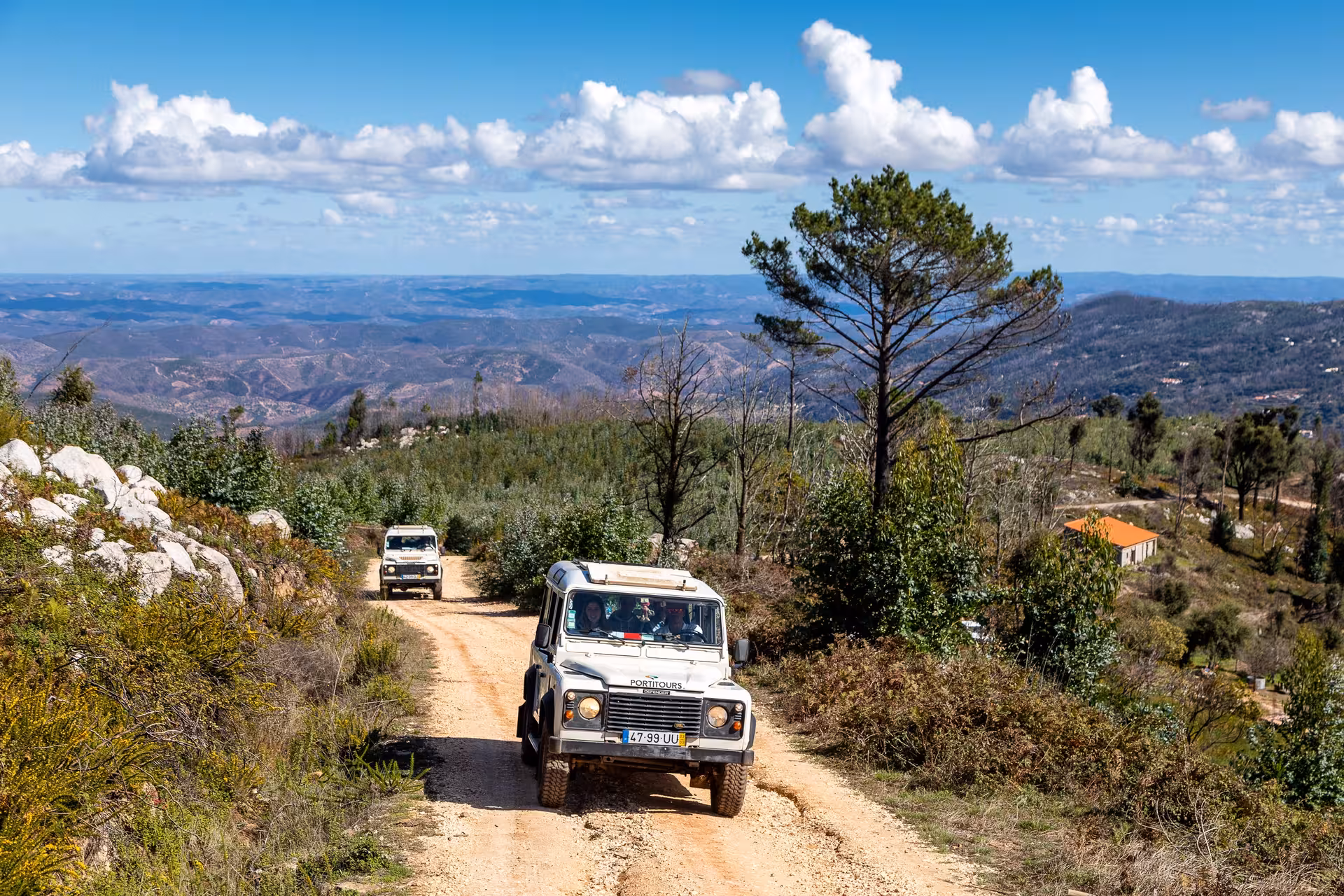 4x4 jeeps driving along a rugged Algarve mountain trail under blue skies on an off-road Portugal jeep safari adventure