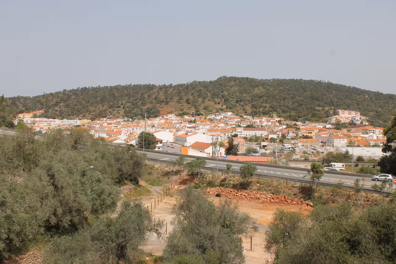 Panoramic Algarve hillside town with red roofs, seen on Jeep safari coast tour near Benagil cliffs