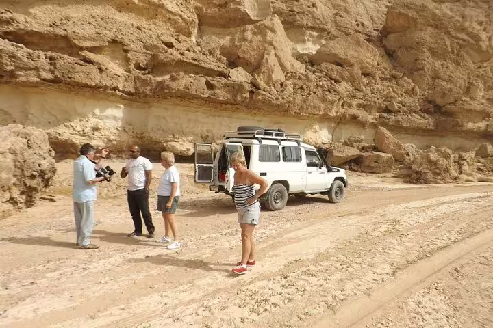 Guests stop by a 4x4 Jeep in rocky Marsa Alam desert canyon on safari adventure tour with dinner and show