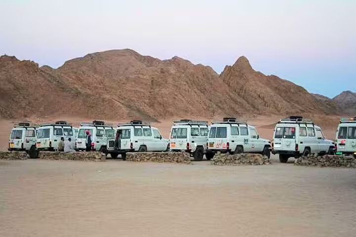 Convoy of 4x4 jeeps in the Marsa Alam desert mountains, ready for a Jeep safari tour with dinner and show