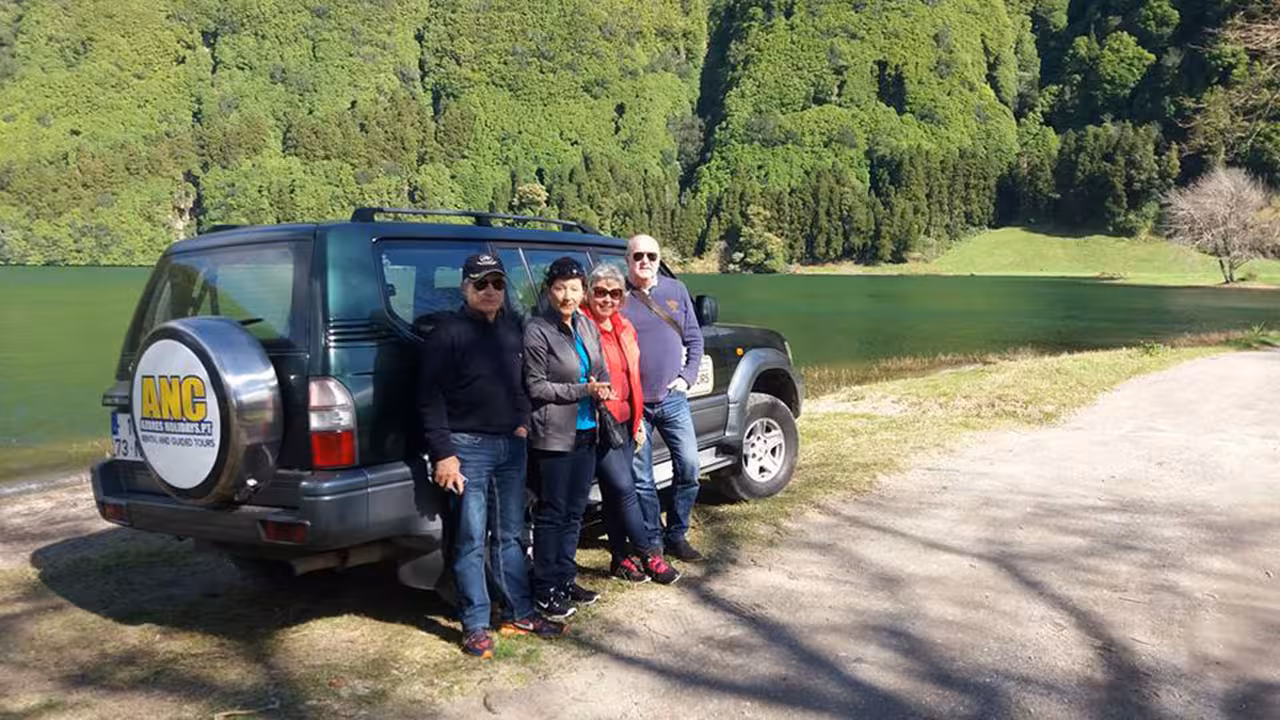 Small group beside ANC 4x4 Jeep by emerald Sete Cidades lake, enjoying full-day off-road Azores nature excursion