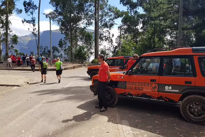 Tourists prepare for a Jeep adventure in Câmara de Lobos, surrounded by lush Madeira landscapes and rugged terrain.