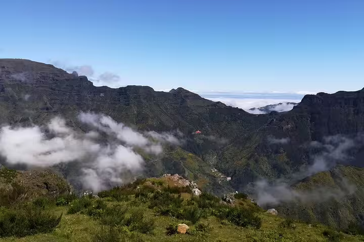 Breathtaking mountain landscape with misty clouds and lush greenery seen from a Câmara de Lobos jeep tour.