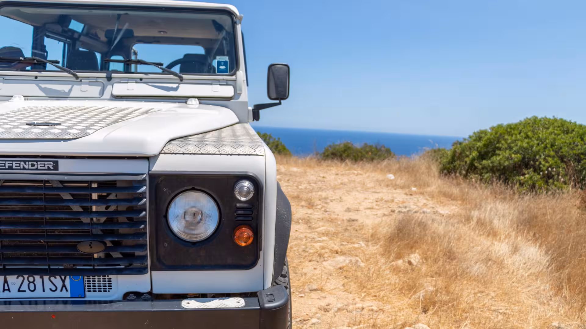 Front view of Jeep overlooking the sea on the scenic Biderosa and Capo Comino private tour from Orosei.