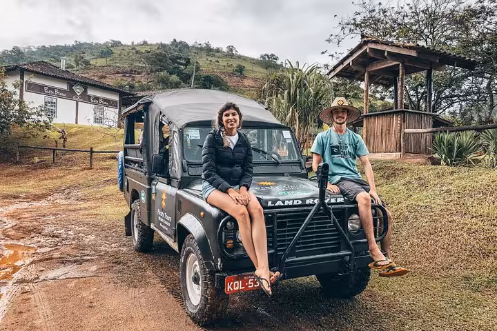 Adventurous travelers sitting on a rugged Jeep ready for a scenic tour to waterfalls and distilleries.