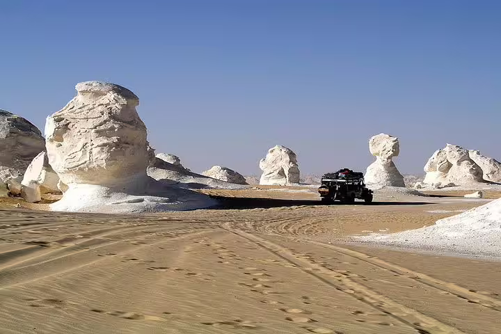 4x4 jeep crosses White Desert chalk rock formations on Siwa Bahariya tour, Egypt 7 days 6 nights package
