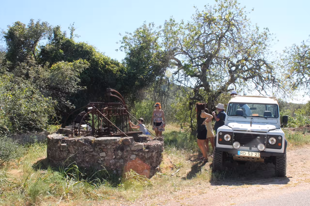 Jeep Zoofari guests stop by a rustic well in the Algarve countryside beside an open-top 4x4 jeep
