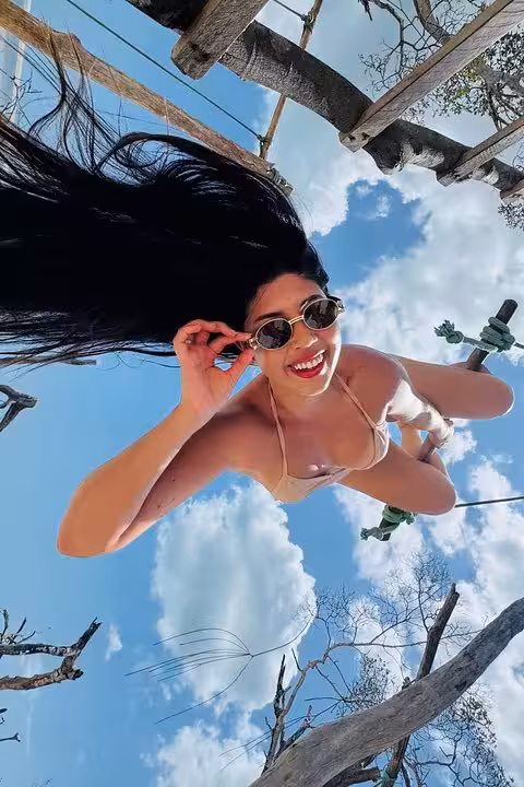 Traveler swinging on a beach hammock under blue skies on Jericoacoara West Coast tour in Ceará, Brazil