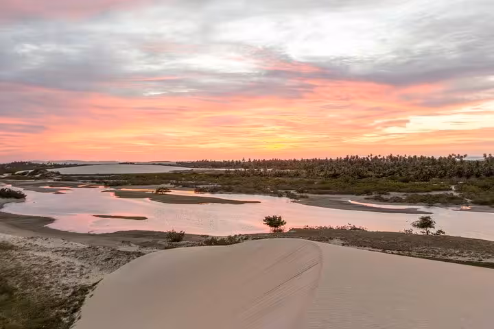 Sunset over dunes and lagoons on Jericoacoara West Coastal Tour, Ceará coastline with winding river