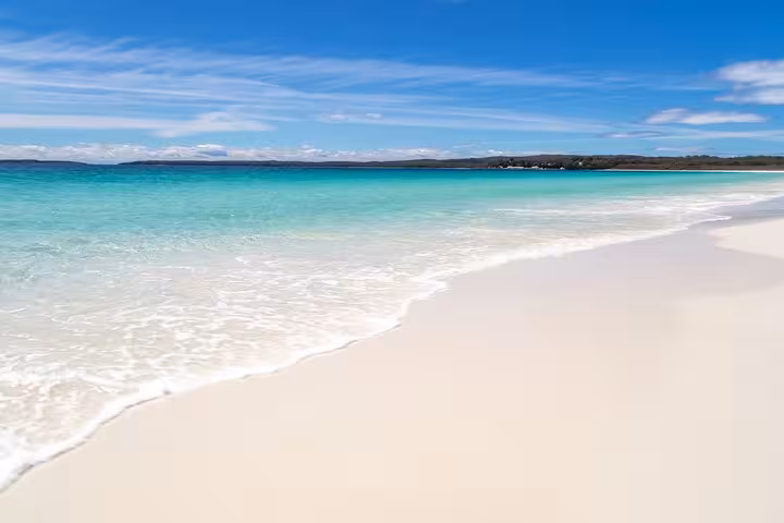 Pristine white sands and turquoise waters of Jervis Bay beach, a highlight of private tours with seamless transport.