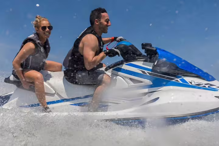 Action close-up of two people on a jet ski in Ibiza, San Antonio to Es Vedrá excursion with spray