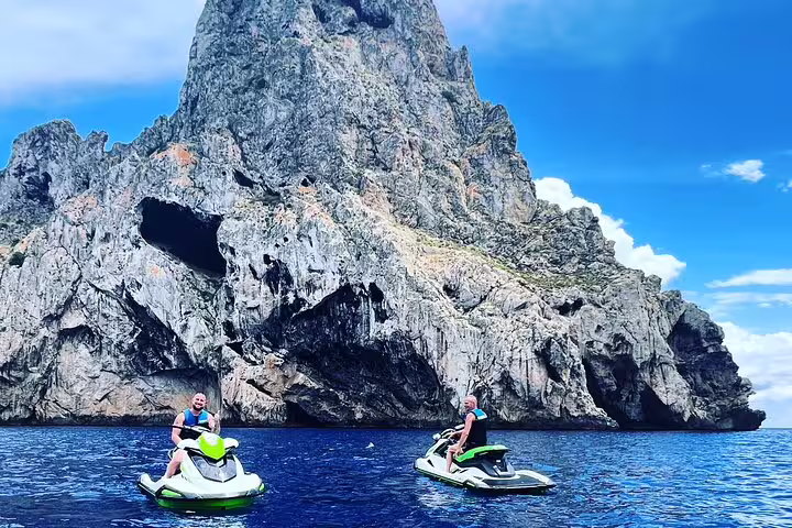 Guided jet ski excursion from San Antonio Ibiza to Es Vedrà, riders cruising by dramatic sea cliffs