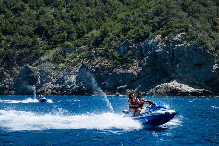 Jet ski speeding along Ibiza coastline near San Antonio, guided tour to Margaritas Islands with spray
