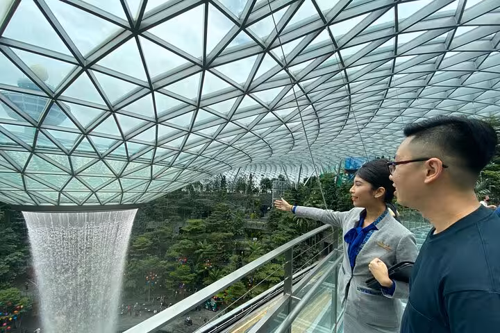 Visitors on Jewel Changi Airport Canopy Park walkway overlooking HSBC Rain Vortex and indoor gardens