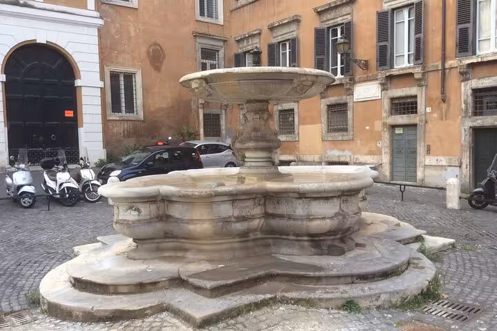 Historic fountain in a quaint Roman square, reflecting the architectural charm of the Jewish Ghetto.