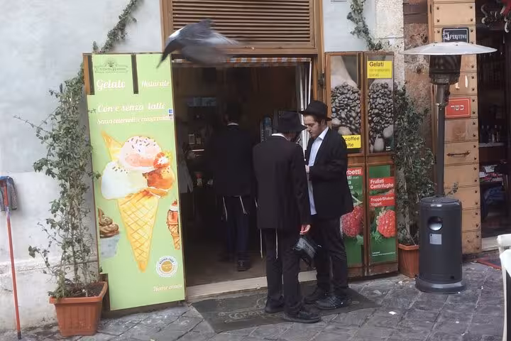 Visitors in traditional attire outside a gelato shop in the Jewish Ghetto, showcasing Roman-Jewish culinary influence.