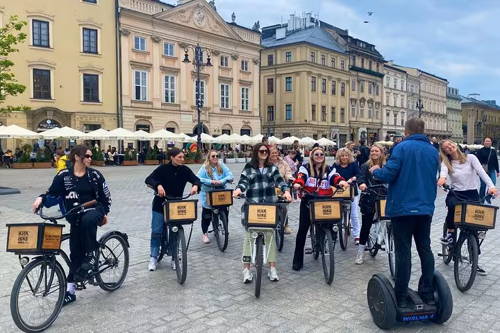 Tour group with bicycles and a guide on a segway in the Jewish Quarter, surrounded by historic architecture.