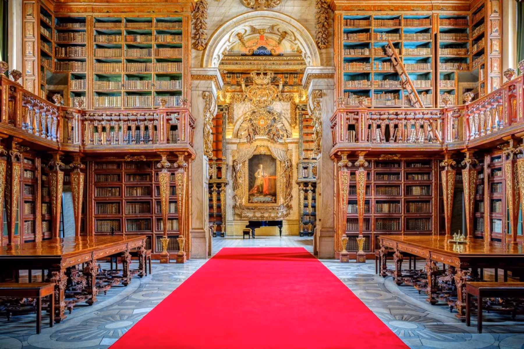 Joanina Library interior at Coimbra University with ornate shelves and red carpet, highlighting Baroque design.