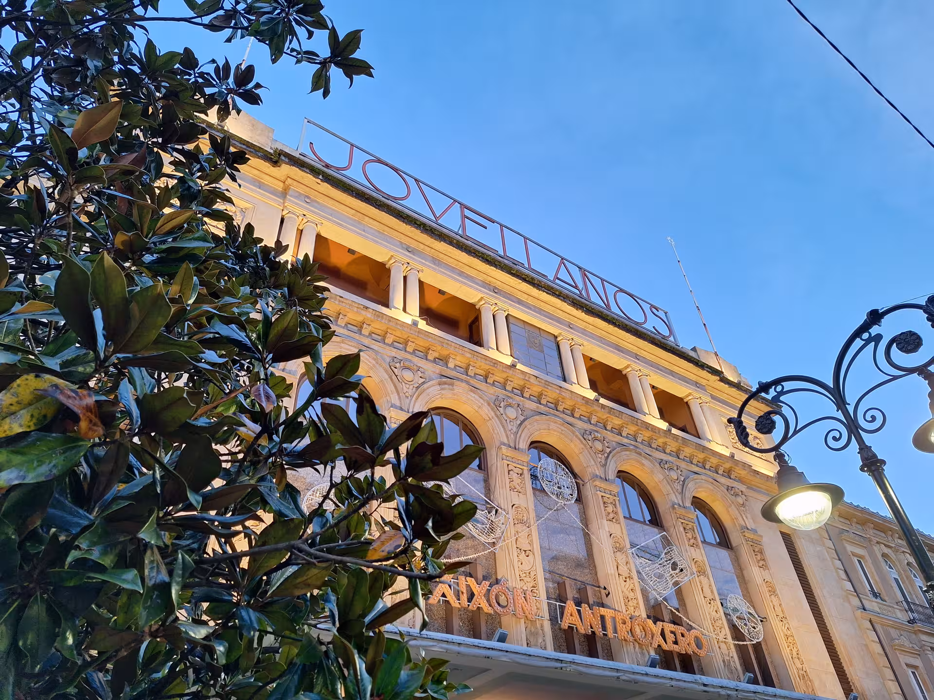 Facade of Jovellanos Theatre in Gijon, a highlight of the Cultural City Bus Tour, under a clear blue sky.