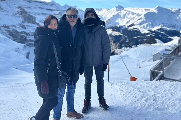 Tourists enjoying snowy landscapes at Jungfraujoch with stunning mountain views on a private day trip.