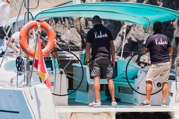 Crew members on the Kailani yacht ready for a sailing adventure with whales and dolphins in the open sea.