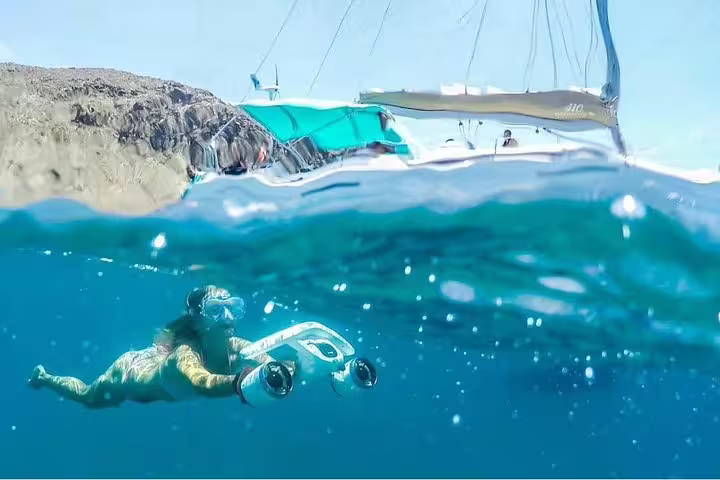 Snorkeler exploring underwater near Kailani Yacht with scenic backdrop, enjoying marine adventure and clear waters.