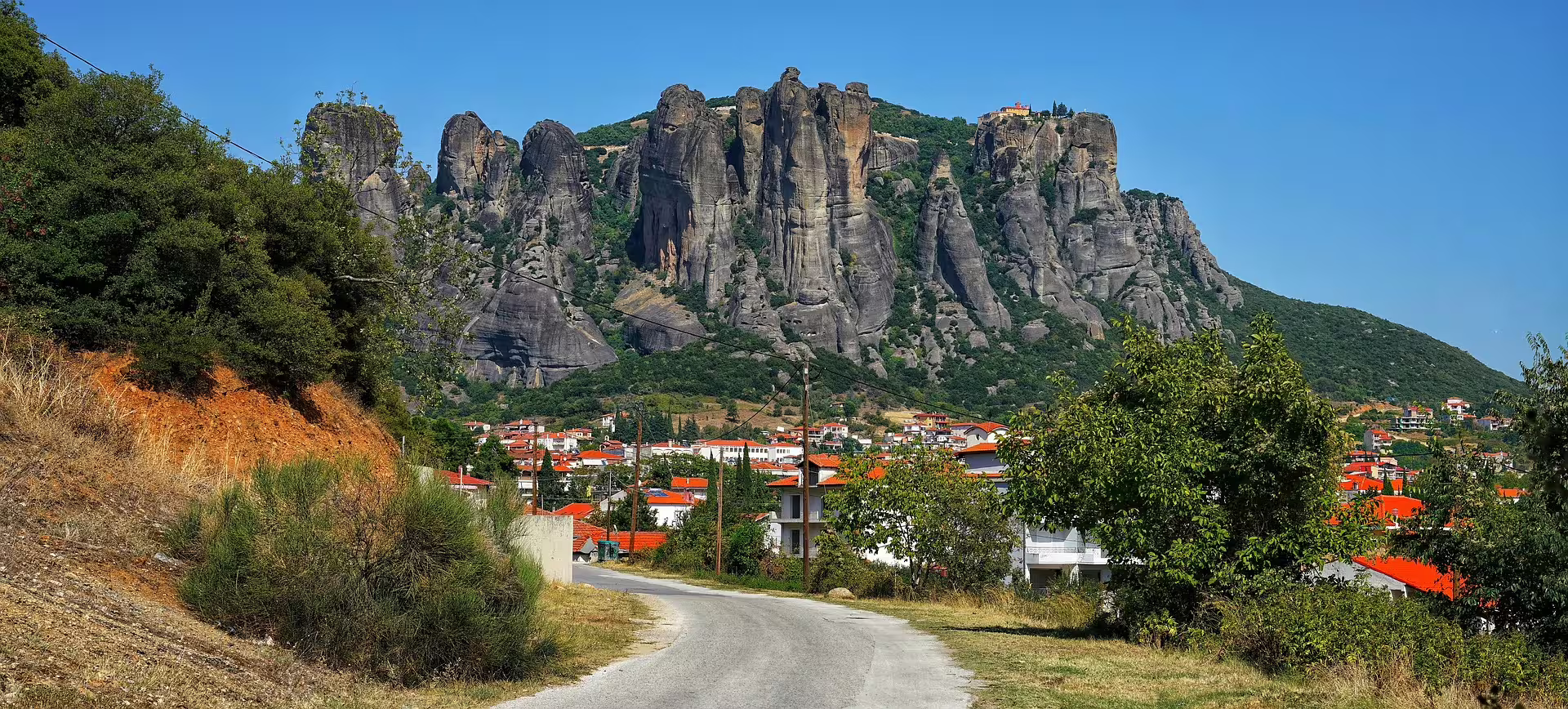 Road view to Kalambaka village beneath Meteora sandstone towers, part of 2-day private tour from Athens and Corinthia