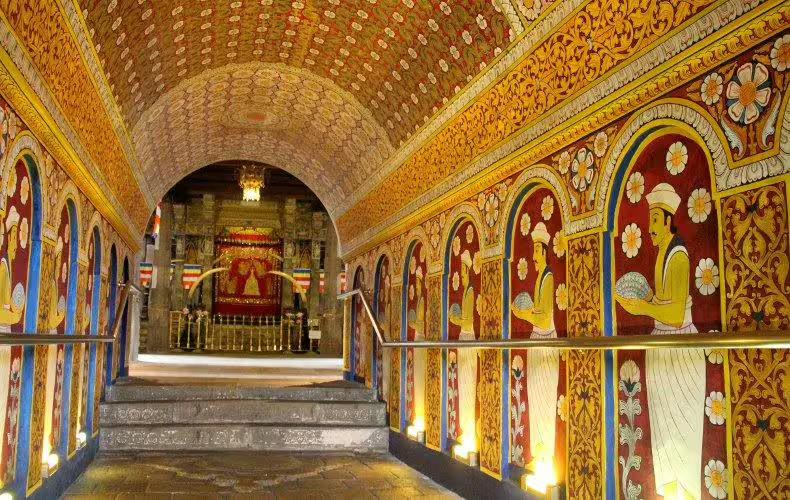 Vibrant mural-lined corridor inside the Temple of the Sacred Tooth Relic, capturing the essence of Kandy's cultural heritage.