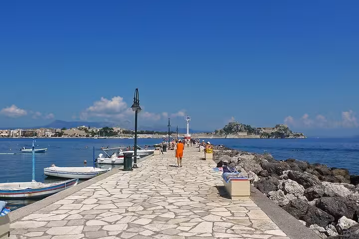 Kanoni seaside promenade with boats and lighthouse, a must-see stop on Top 5 Corfu highlights tour