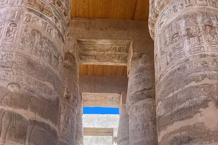 Intricately carved columns inside Karnak Temple, highlighting ancient Egyptian hieroglyphs and monumental architecture.