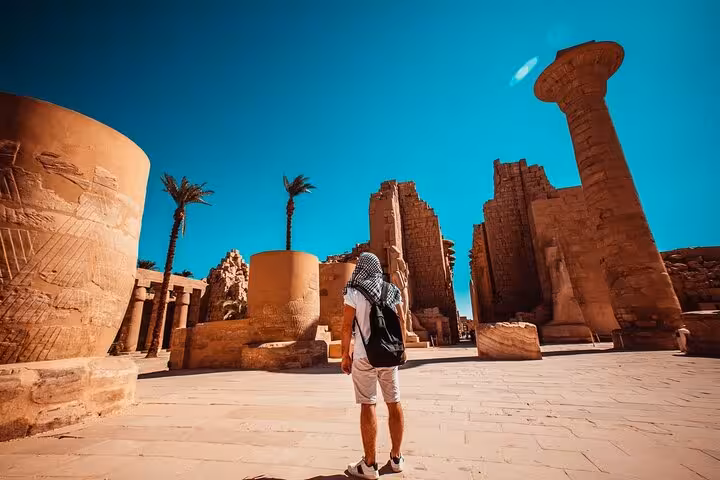 Tourist walking among massive Karnak Temple columns in Luxor, full-day tour from Marsa Alam Egypt