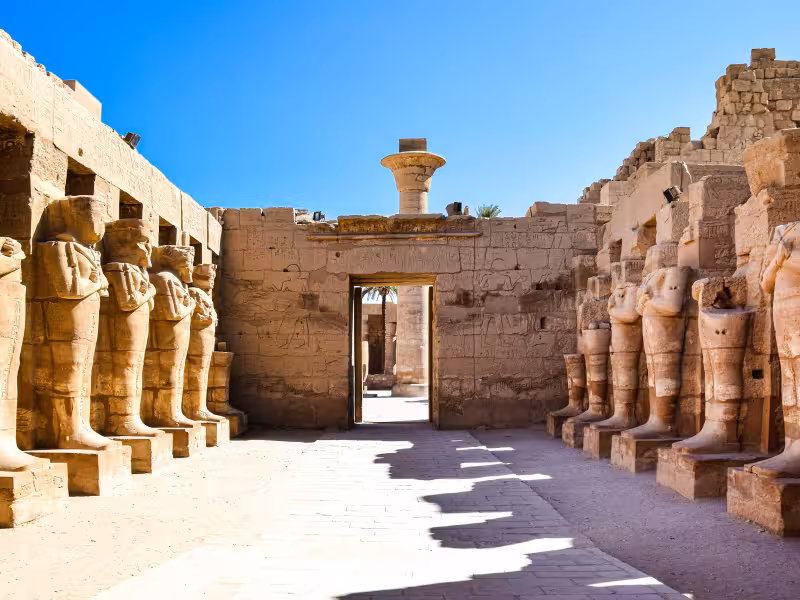 Karnak Temple avenue in Luxor with row of ancient statues and hieroglyphs, Golden Egypt guided tour