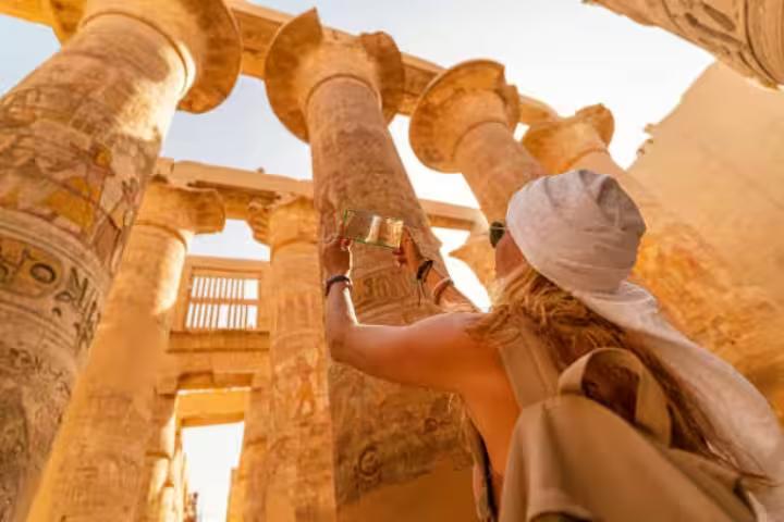 Traveler photographing Karnak Temple columns in Luxor on a 5-day Cairo Luxor Abu Simbel tour package by air