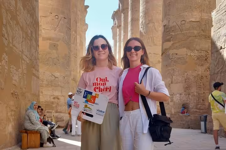 Tourists pose inside Karnak Temple columns on Luxor day trip by plane from Sharm El Sheikh, Egypt