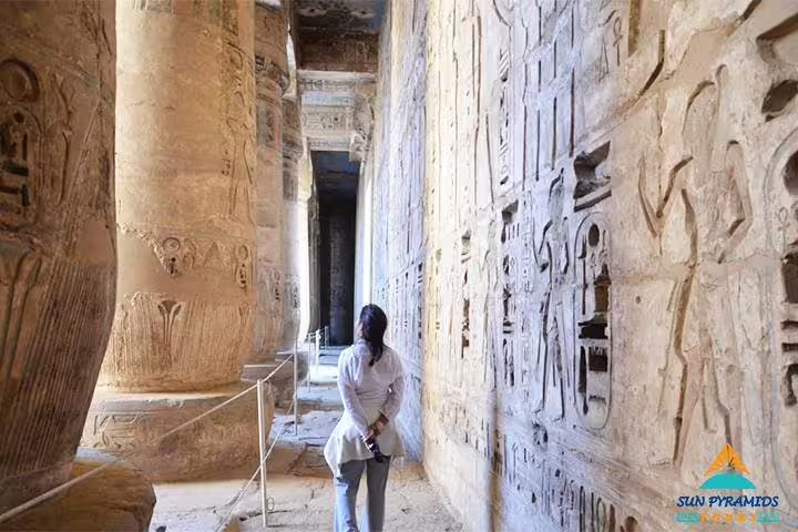 Visitor in Karnak Temple corridor with hieroglyphs in Luxor, part of 12 day Egypt tour to Aswan and Hurghada