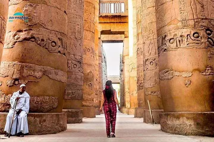 Tourist between towering Karnak Temple pillars in Luxor on a private Hurghada to Luxor day tour by car