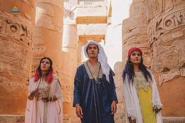 Visitors in traditional dress walking between Karnak Temple columns, Luxor East Bank Nile guided tour