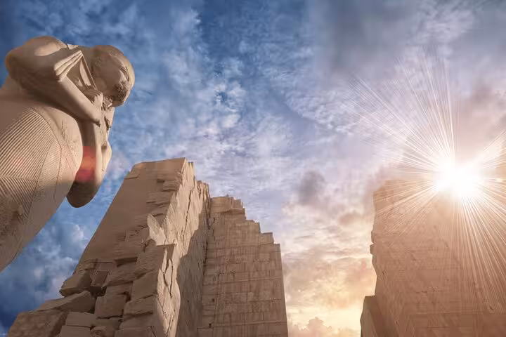 Karnak Temple ruins and colossal statue at sunrise in Luxor, featured on the Temple of Hatshepsut 5-day trip from Cairo