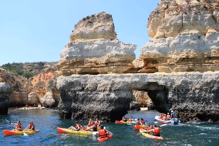 Kayak cave tour in Lagos Algarve with group paddling under Ponta da Piedade rock arch on turquoise water