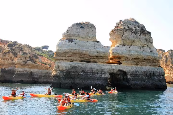 Guided kayak tour past Ponta da Piedade sea stacks in Lagos Algarve, paddling calm turquoise waters