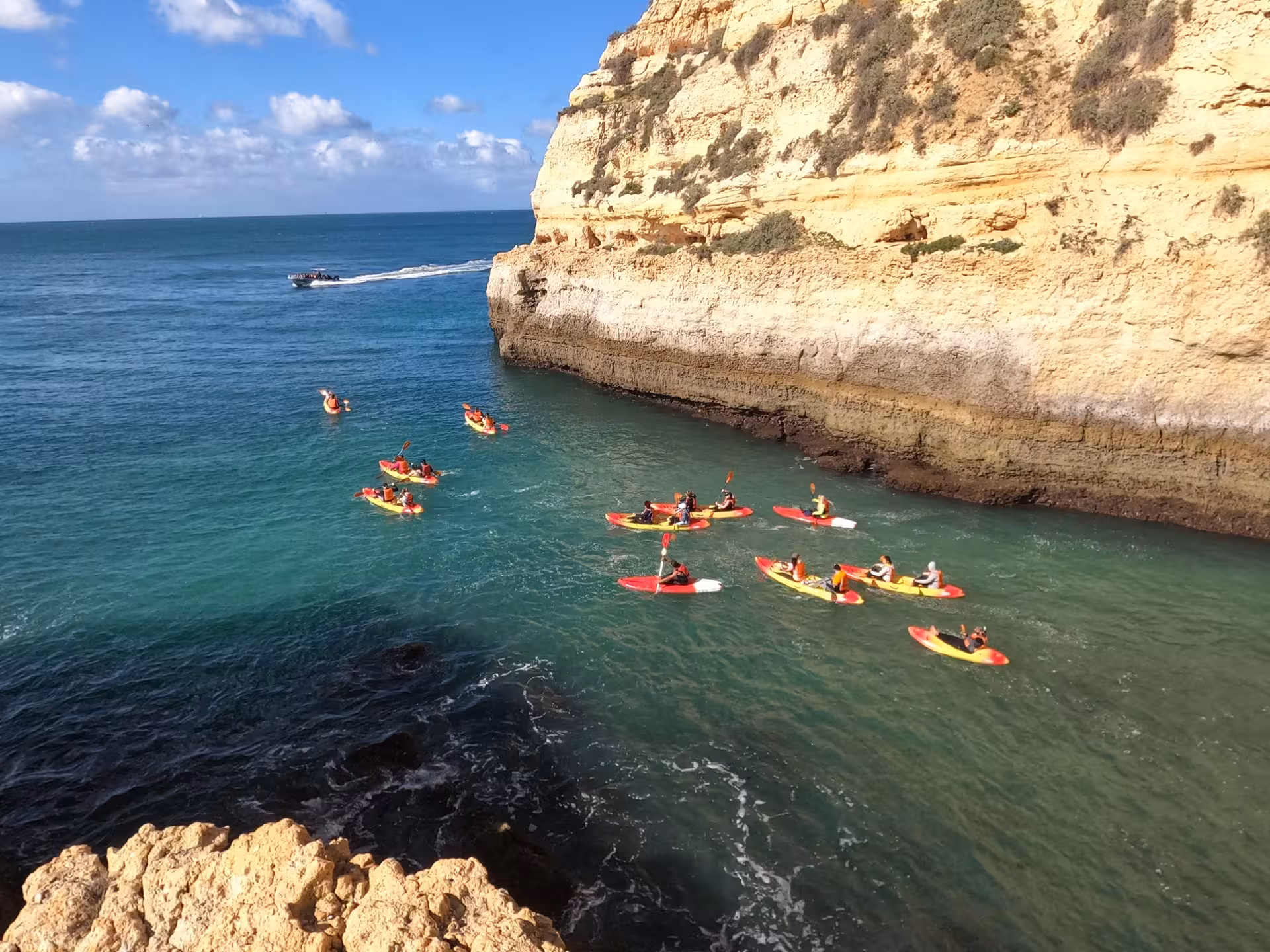 Group of kayakers exploring stunning Benagil coastline on a sunny day, ideal for Algarve sea adventures.