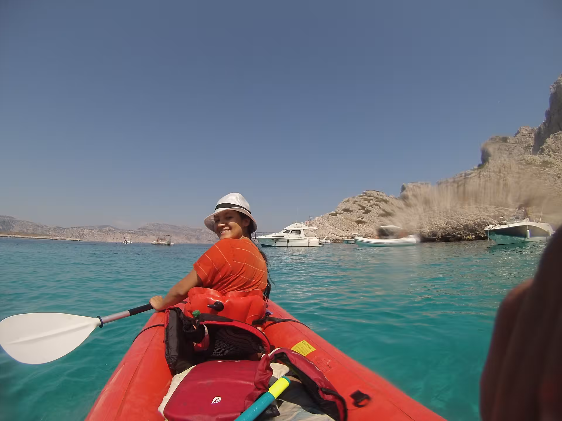 Femme pagayant en kayak de mer à Giens sur eau turquoise, excursion guidée vers criques et falaises