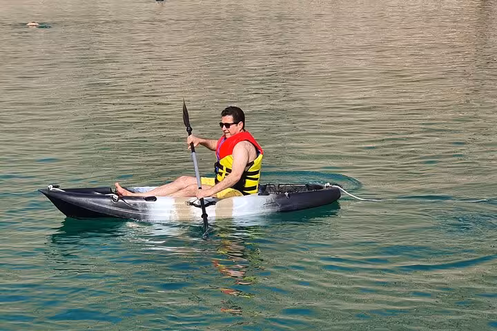 Kayaking on Hatta Dam Lake during a private full-day tour from Dubai, enjoying calm turquoise waters