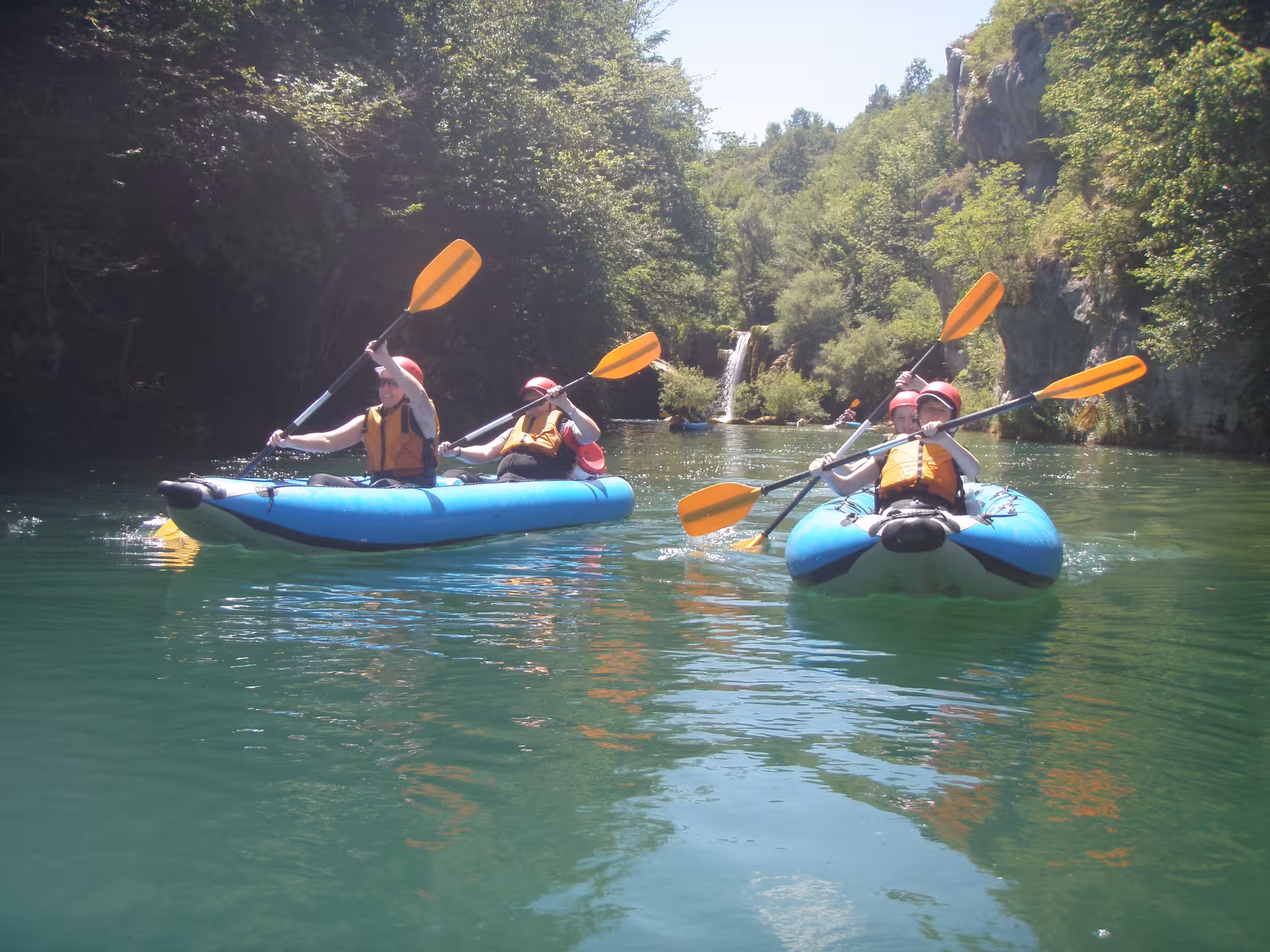 Two kayaks with paddlers gliding through clear waters of Mreznica Canyon, offering an exhilarating nature experience.