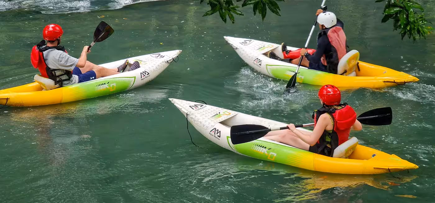 Group of kayakers with helmets enjoy a thrilling ride on the clear waters of Río Frío, great for adventure seekers.