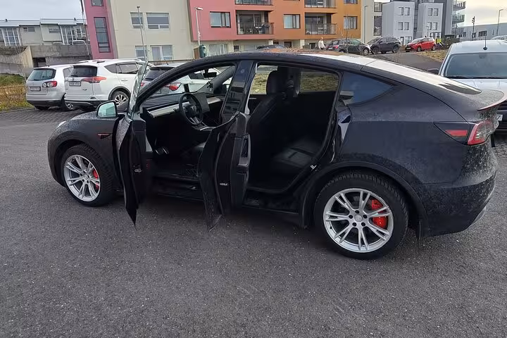Sleek black car with open doors ready for a private transfer from Keflavik Airport to Reykjavik city center.