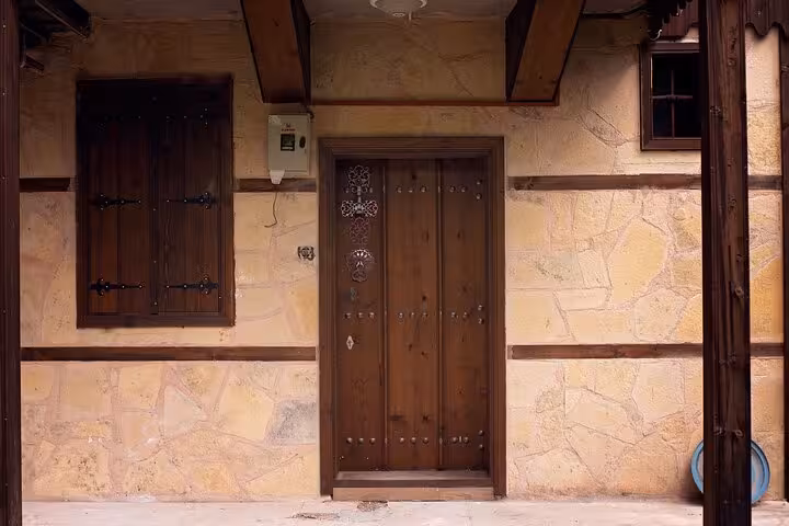 Traditional Kemaliye stone house facade with wooden shutters, featured on private 2-day tour from Erzincan
