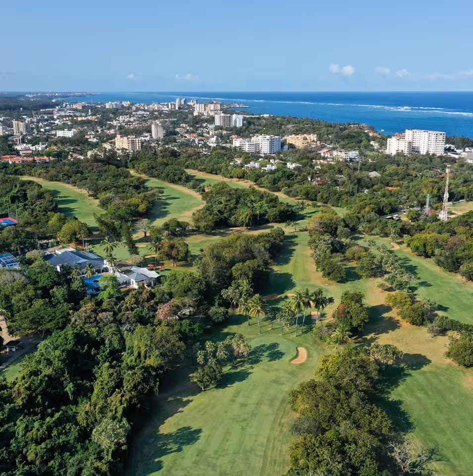 Scenic aerial view of a lush golf course near the coast, highlighting the Kenya Coast Golf Experience's natural beauty.