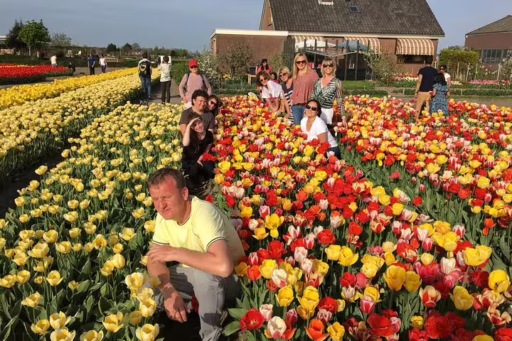 Tour group posing among colorful tulip fields near Keukenhof on a half-day tulip paradise trip from Amsterdam