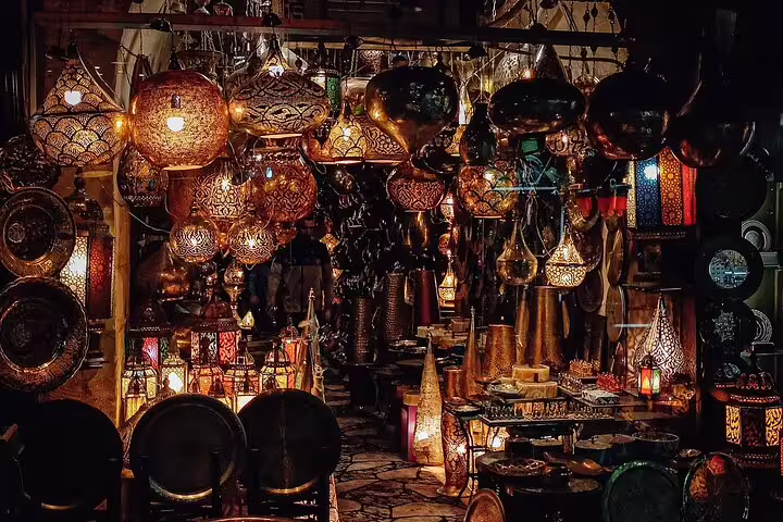 Khan el-Khalili bazaar stall with glowing brass lanterns and metalware on a Medieval Cairo shopping tour